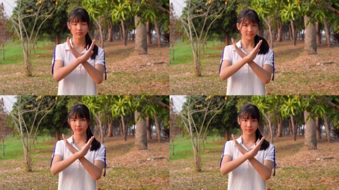 运动的亚洲年轻女子的面部表情，拟人化的笑脸，拒绝手势