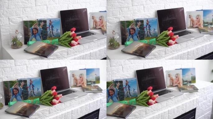 带花的白色架子上的笔记本电脑。郁金香，相册。