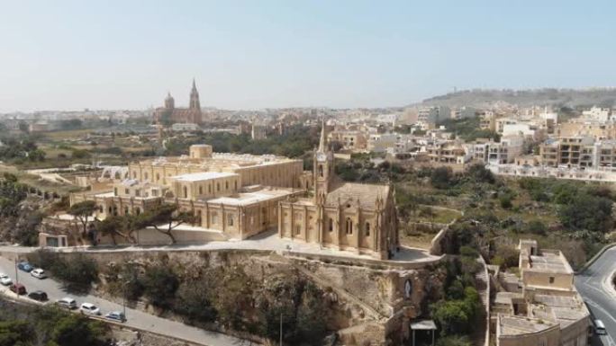在马耳他地中海小镇Mgarr-Gozo的Ghajnsielem教堂周围环绕的4k空中无人机镜头