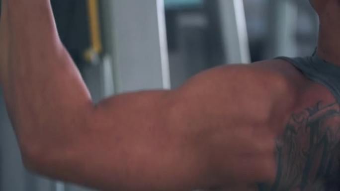 亚洲男子使用背部肌肉训练机