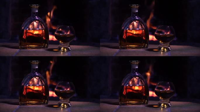 壁炉火背景下的威士忌或白兰地酒瓶和玻璃杯