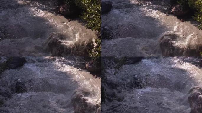 暴风雨的河水冲刷着大石头，喷雾和泡沫在飞舞。慢动作视频