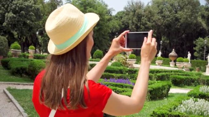 女人在手机上慢动作拍照。女游客在博尔盖塞别墅拍照