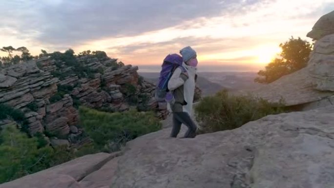 带着背包在黎明山攀登的高级女性侧视图