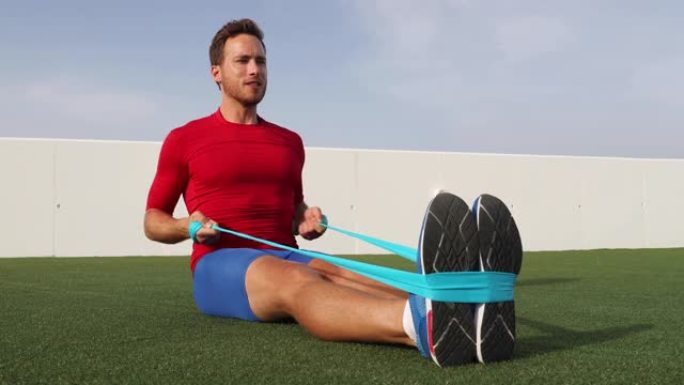 健身男子训练带阻力带的手臂做坐式排行运动