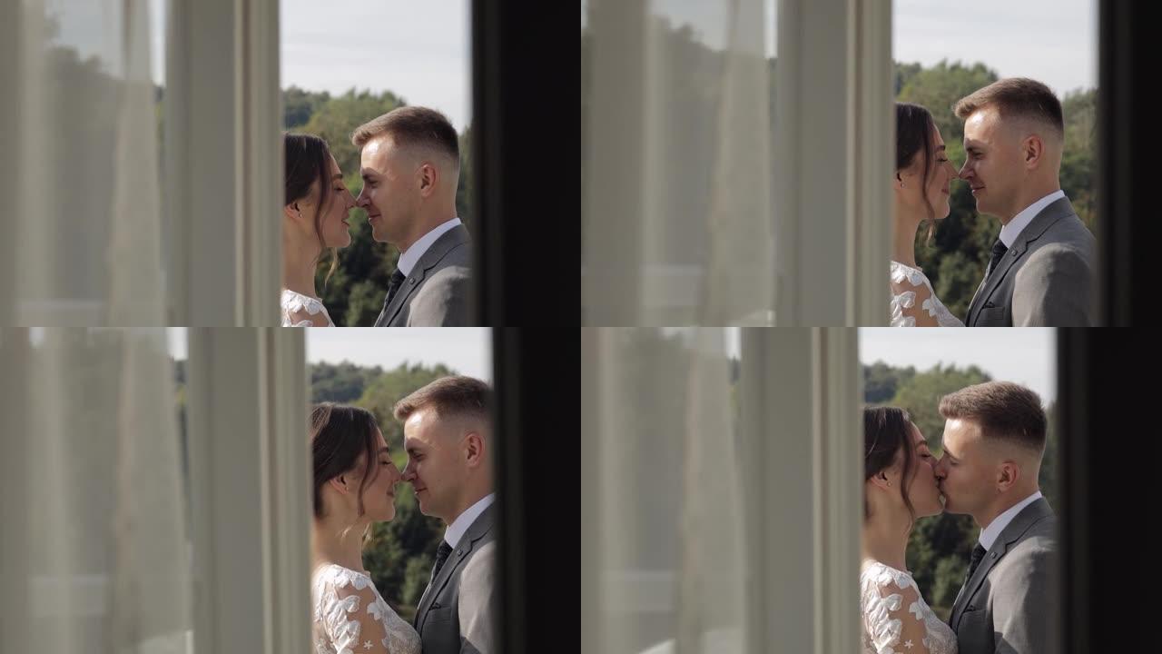 高加索新婚新娘在酒店房间的阳台上拥抱新郎，慢动作