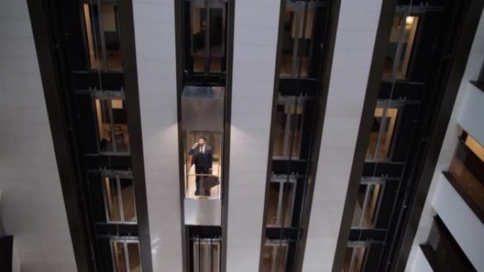 带酒店客人的上升电梯轿厢上方视图