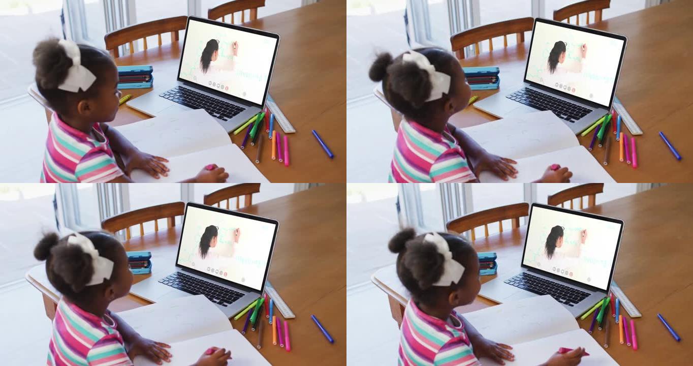 非裔美国女孩在家里用笔记本电脑与女老师进行视频通话时做作业