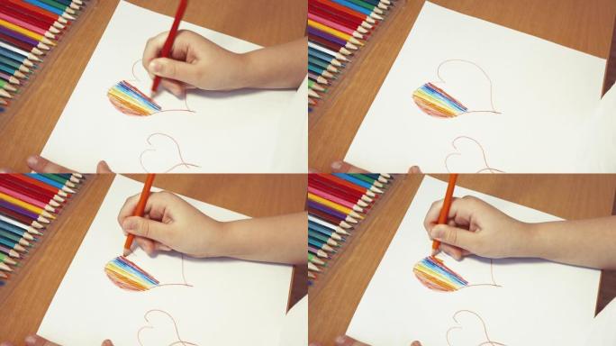 彩虹心特写由儿童用彩色铅笔双手绘制