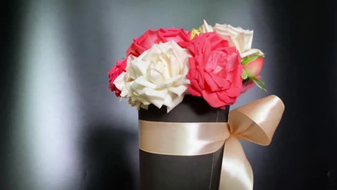 4k粉色和白色玫瑰花束旋转。给女人的鲜花礼物。一束鲜花在大理石白色和黑色背景上旋转。