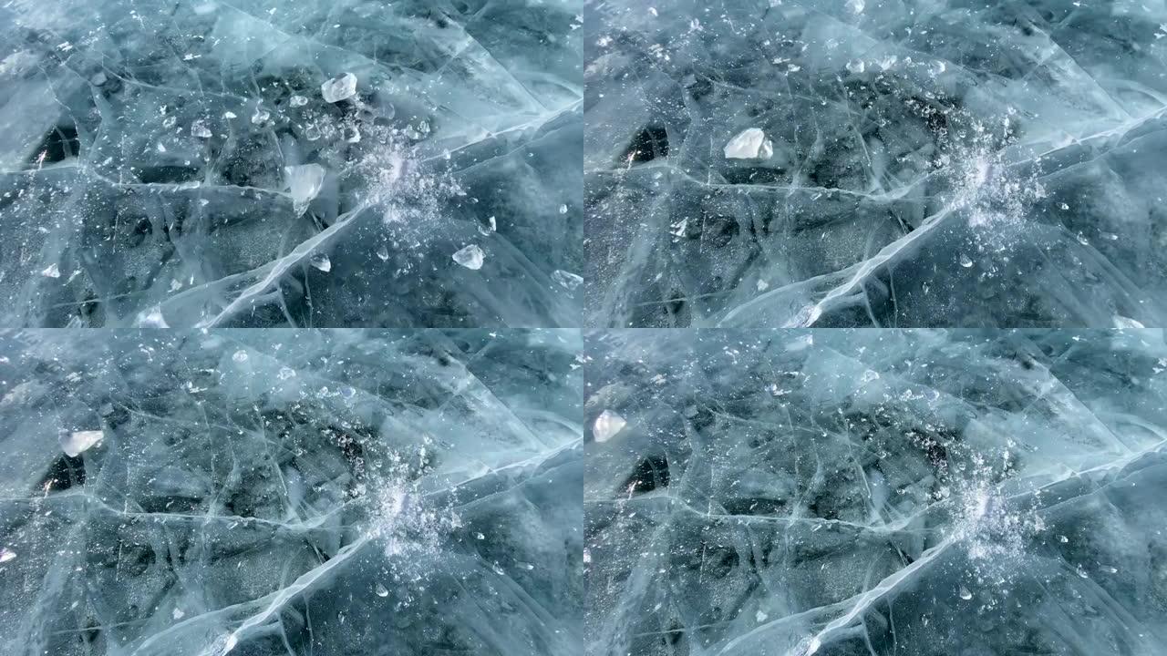慢镜头视频，一块冰从高处坠落，在冰冻的贝加尔湖光滑透明的蓝色冰上破碎。