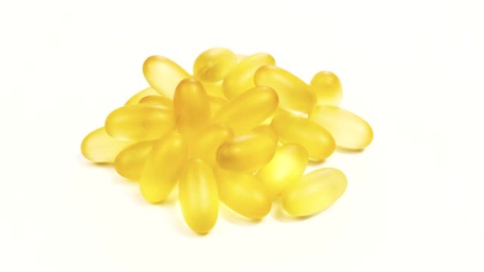 有机补充剂维生素黄色胶囊欧米茄3或D-3药丸在白色背景，微距拍摄。膳食补充剂，特写。4k