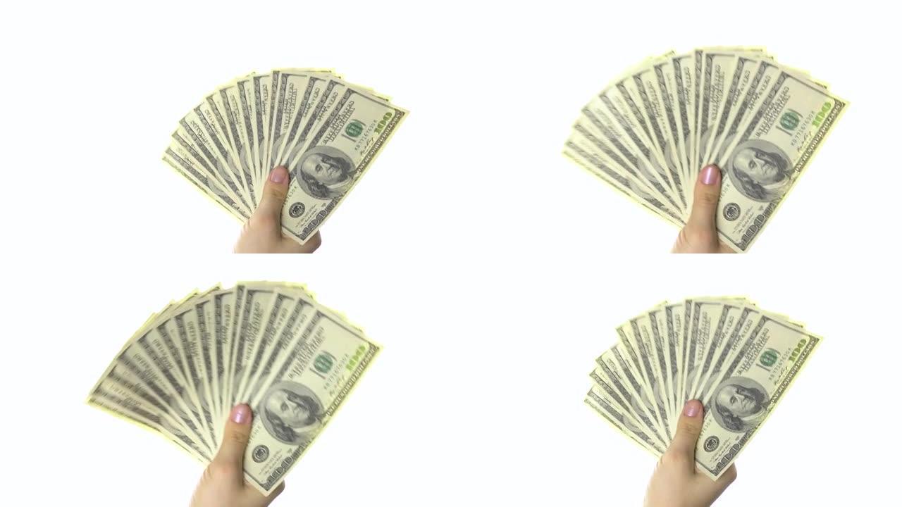 女人的手像扇子一样挥舞着一百美元的钞票。白色背景。