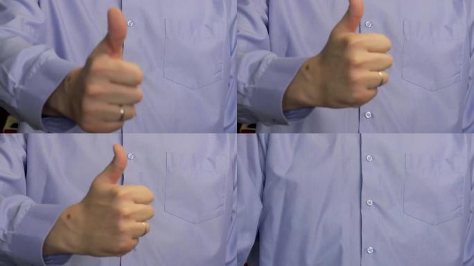 这个人竖起大拇指。一个穿蓝色条纹衬衫的男人。