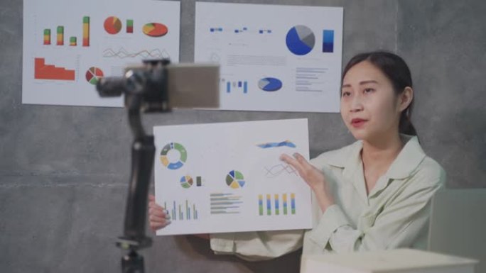 亚洲女性使用图形和数据教学理财规划师手机视频聊天