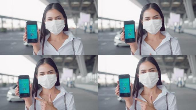 特写一名女商人在国际机场戴着防护口罩，在智能手机上展示疫苗护照，在新型冠状病毒肺炎概念下旅行