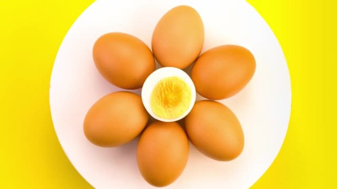 鸡蛋整体和白色的一半在黄色背景上。