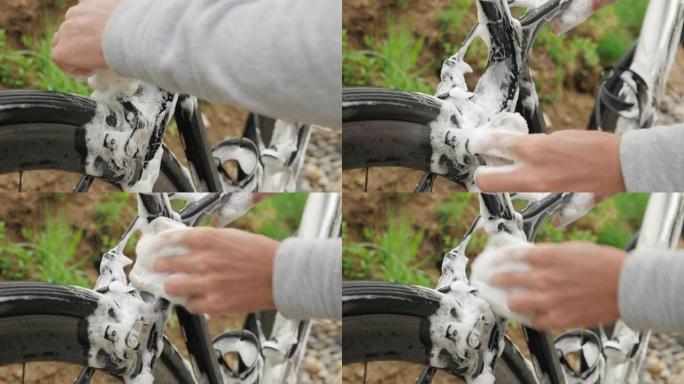 用泡沫清洗自行车。男人用水和毛巾洗自行车。自行车细节