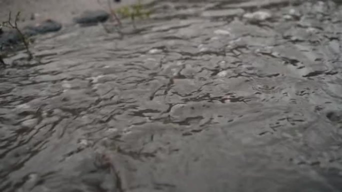 倾盆大雨时，肮脏的水流在地面上流动。外面的天气很糟糕