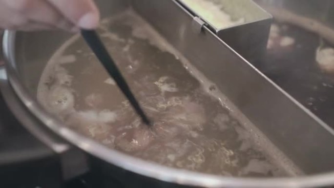 筷子在sha锅锅中摆动肉片