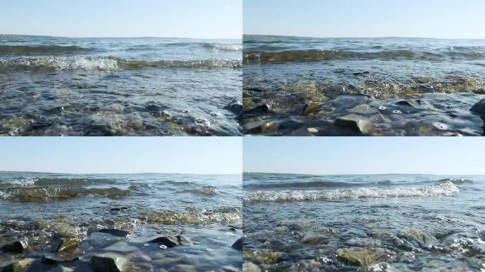 海浪在岸上，特写。海水清澈，自然海洋背景。黎明日出日落在海洋。暑假放松概念。太阳的光线。