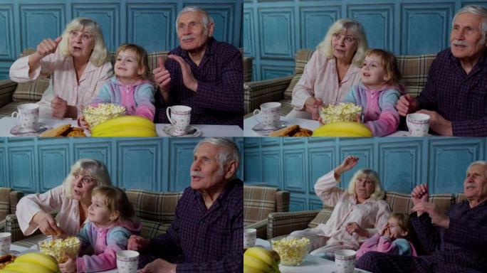 高级爷爷和奶奶开心地笑，吃爆米花，在家看卡通片