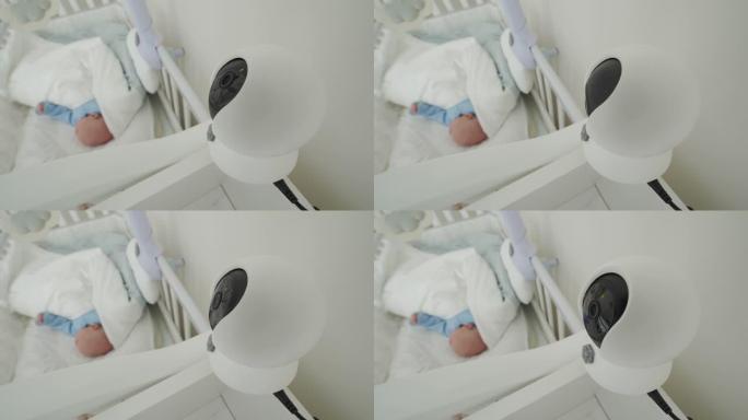 Ip摄像机作为卧室婴儿床上方的婴儿监视器摄像机，刚出生的男婴在床上安详地睡觉。