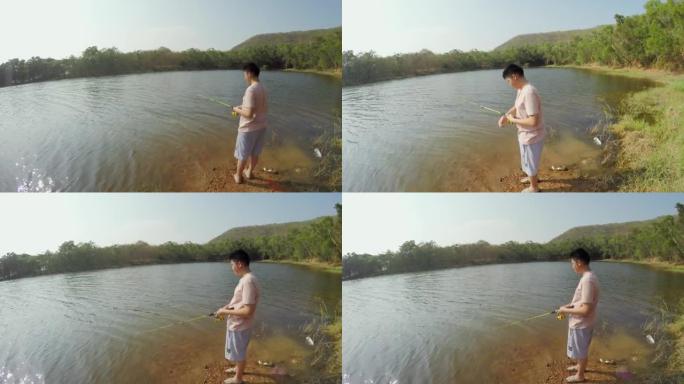 亚洲男孩在度假期间与家人在湖边钓鱼，生活方式理念。