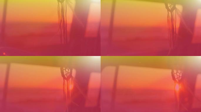 捕梦网在风中运动的动画，背景为黄色至红色，背景为日落