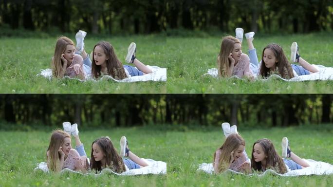 两个可爱的小姐妹在阳光明媚的夏日一起在草地上玩得开心