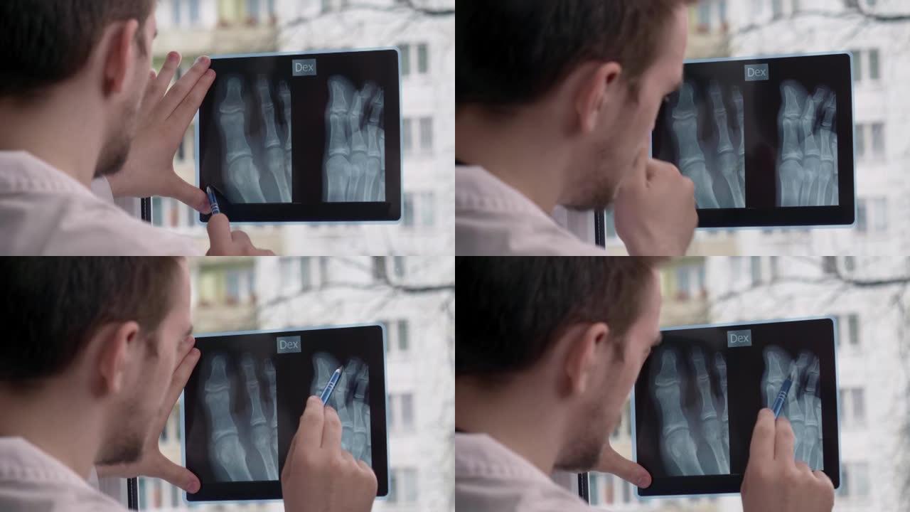 年轻的医生在窗户的背景下看着x射线照片