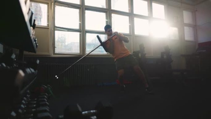 年轻的运动型男子在健身房做单腿地雷深蹲运动
