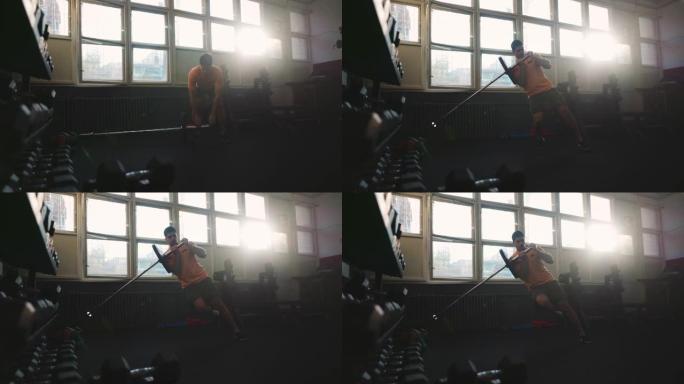 年轻的运动型男子在健身房做单腿地雷深蹲运动