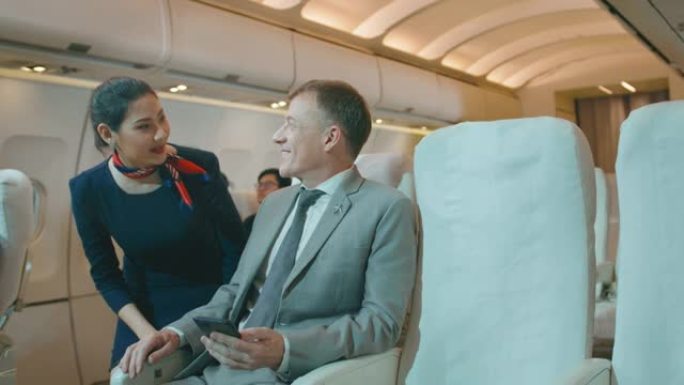 一位美丽的女乘务员向机上乘客微笑问候，生活方式和商务旅行理念