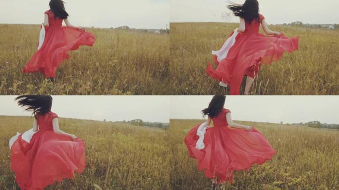 穿着红色连衣裙的美女在秋天的田野里奔跑。慢动作