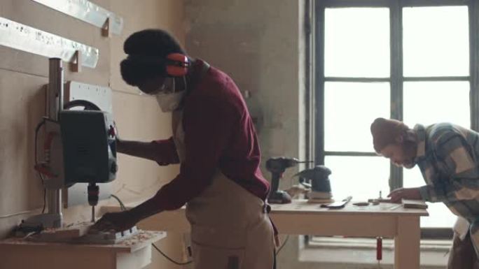 非裔美国人专业木工在车间使用现代设备
