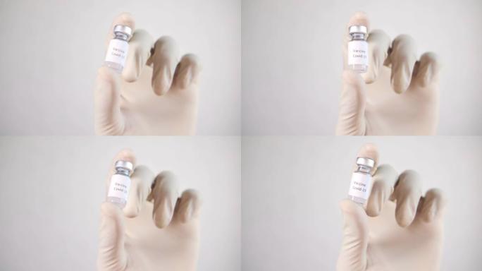 手持乳胶手套，白色背景上的玻璃安瓿疫苗