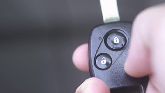 CU手使用汽车钥匙打开和锁定车门。