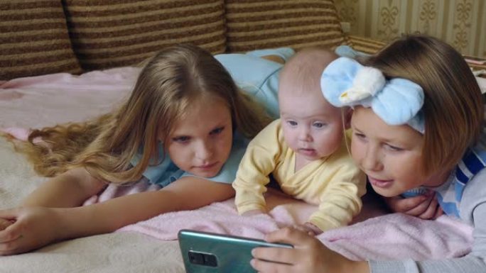 儿童与婴儿一起在智能手机上观看视频