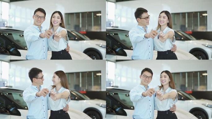 慢莫微笑的年轻夫妇展示车钥匙