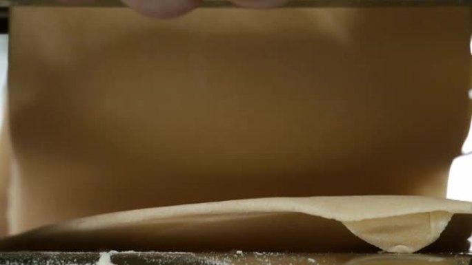 传统的意大利自制面食是在切面团的机器上制作的。从面条机出来的新鲜意大利面，特写镜头。厨师使用意大利面