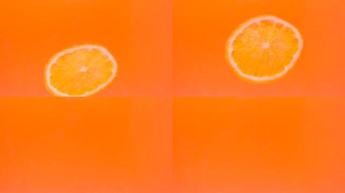一块橙色落在黄色背景上的水中。水下水果。果汁