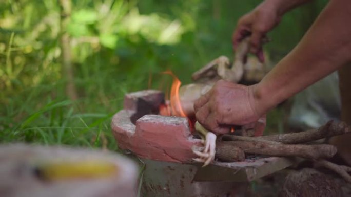 在亚洲火炉上烧焦的红热木炭上烤鸡