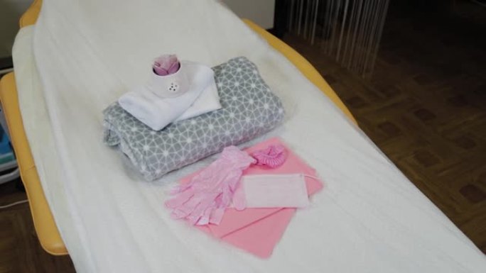 美容院沙发上的粉红色口罩和手套