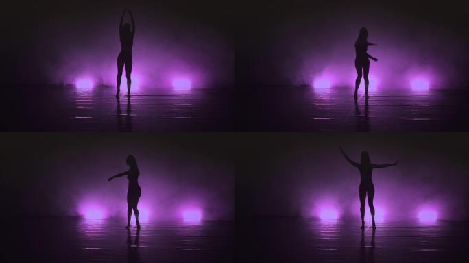 女舞者在黑暗和烟雾中摆出性感的动作