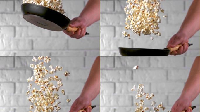 超级慢动作男人的手用煎锅扔爆米花。以1000 fps的高速相机拍摄。