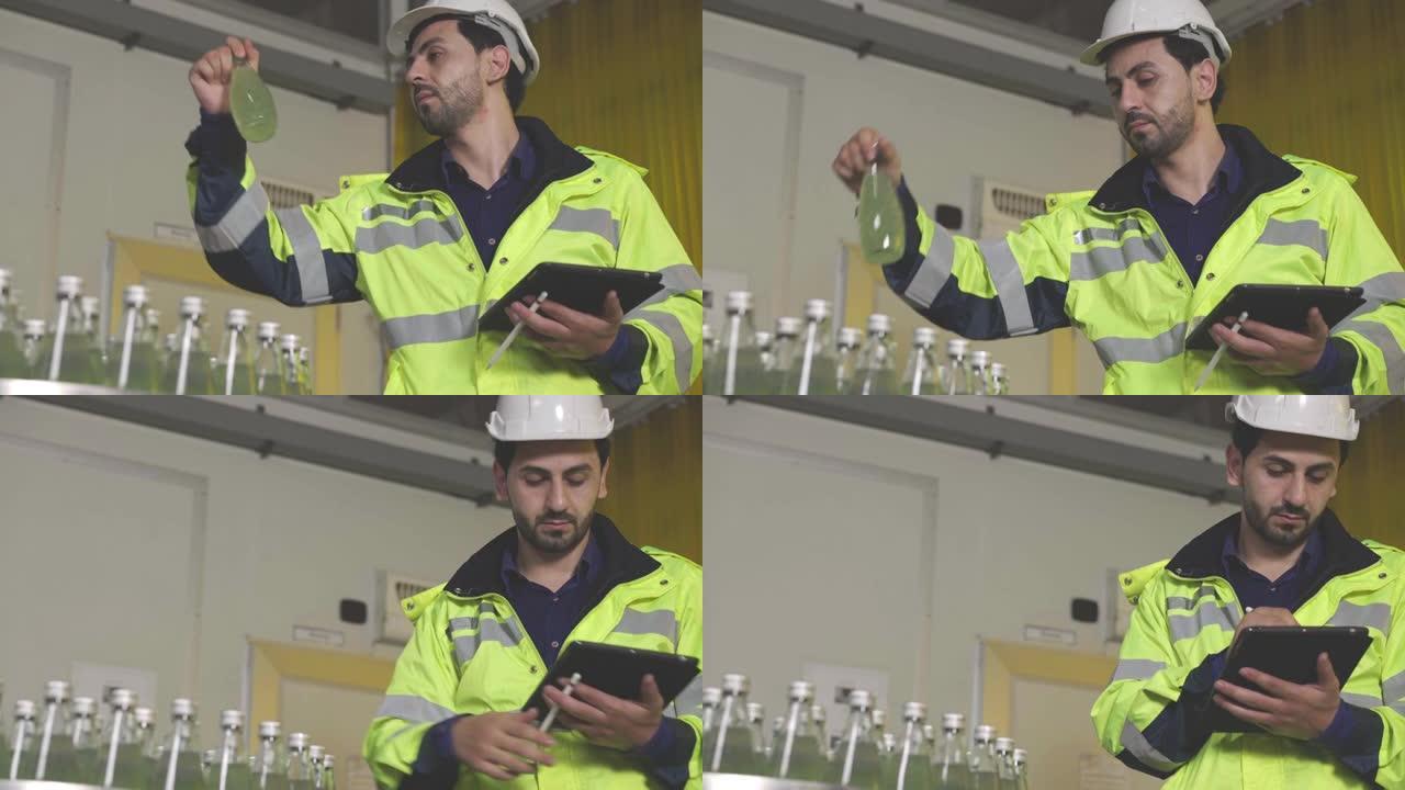 高加索工厂男性经理使用数字平板电脑检查信息和瓶装工厂机械上果汁饮料产品的质量控制。饮料工业生产过程