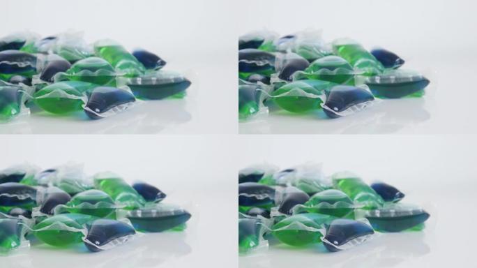 白色表面4k倾斜镜头上的大量绿色和蓝色凝胶洗涤荚