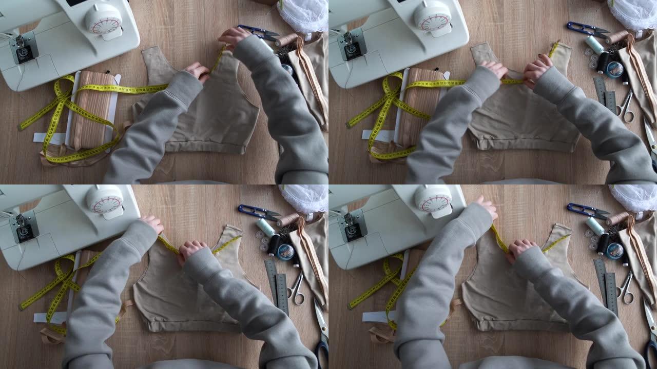 设计师用柔性胶带测量所需织物量的手的俯视图。设计师在工作过程中。小企业概念。4k
