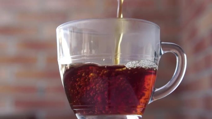 将新鲜蒸红茶倒入室外的透明玻璃杯中